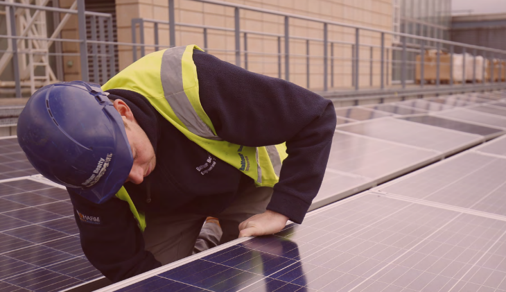 Individual in a high vis jacket installing solar panels