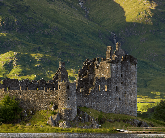 A medieval Scottish castle surrounded by green landscape.
