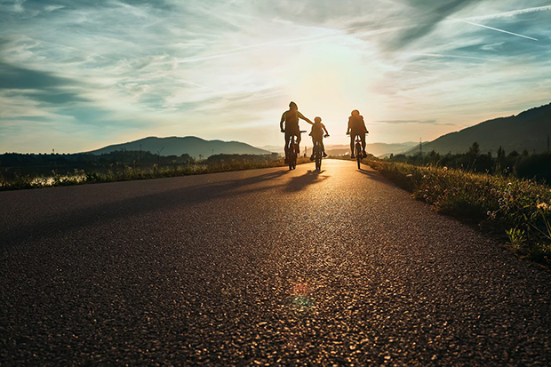 A family cycling along towards hills