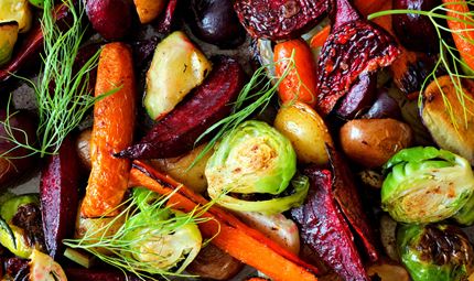 Close up of roasted vegetables including carrots, onions and sprouts.