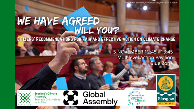 A voter holds up a blue card while sitting in a pew in a voting chamber.