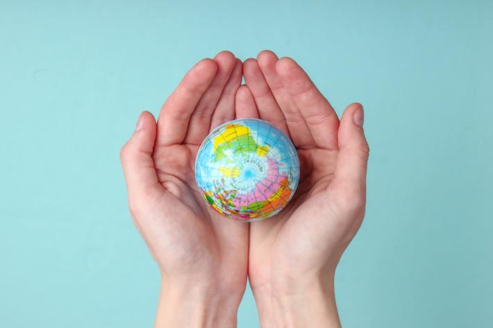 A pair of hands holding a globe