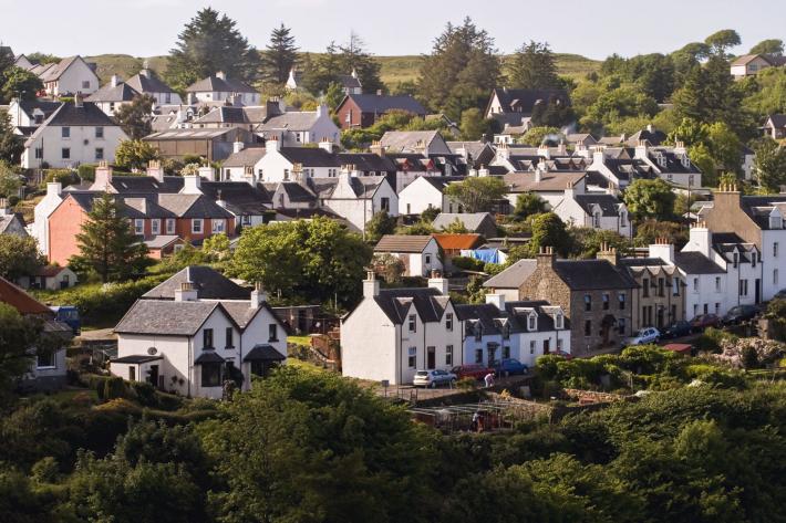 A small Scottish village, with lots of white houses surrounded by greenery