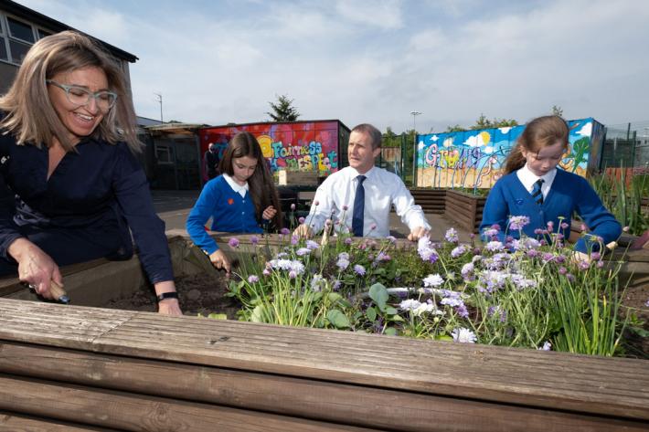 Teachers and school children planting flowers