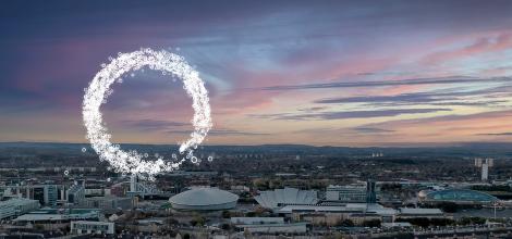 Glasgow sunset skyline with glowing circle graphic floating in the sky.