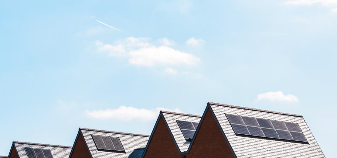 Rooftops of houses with solar panels on them.