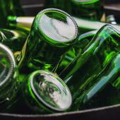 A collection of green glass bottles in a bin