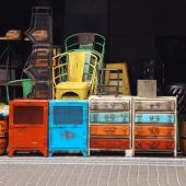Colourful vintage furniture stacked up at the front of a vintage shop
