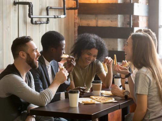 Young people laughing and chatting in a cafe