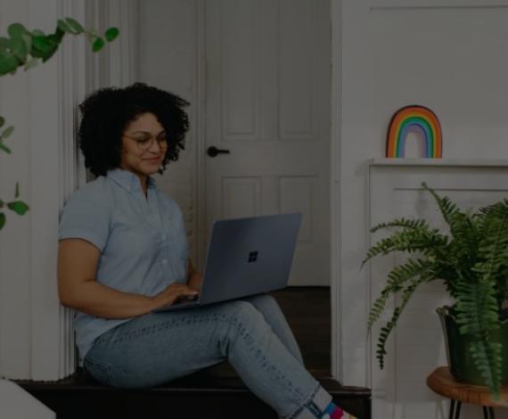 Woman sitting on floor looking at laptop